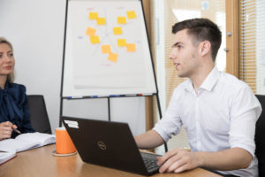 person, laptop, flipchart